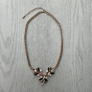Gold necklace with black and pink flower details